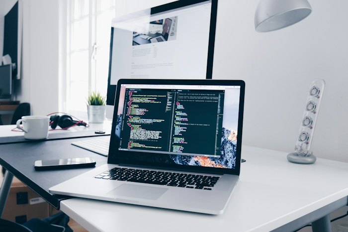 Laptop on a desk showing code