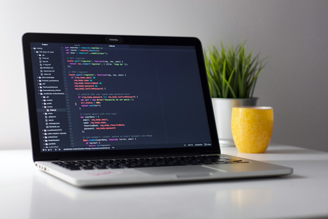 Laptop on a desk showing code in an editor